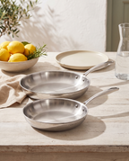 Juego de 2 sartenes de acero inoxidable Tri-Ply Grano en una mesa de terraza de verano