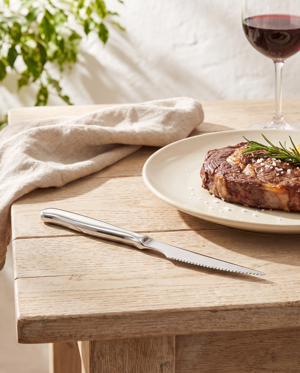 Cuchillo chuletero Zurique sobre una mesa de verano con carne a la brasa