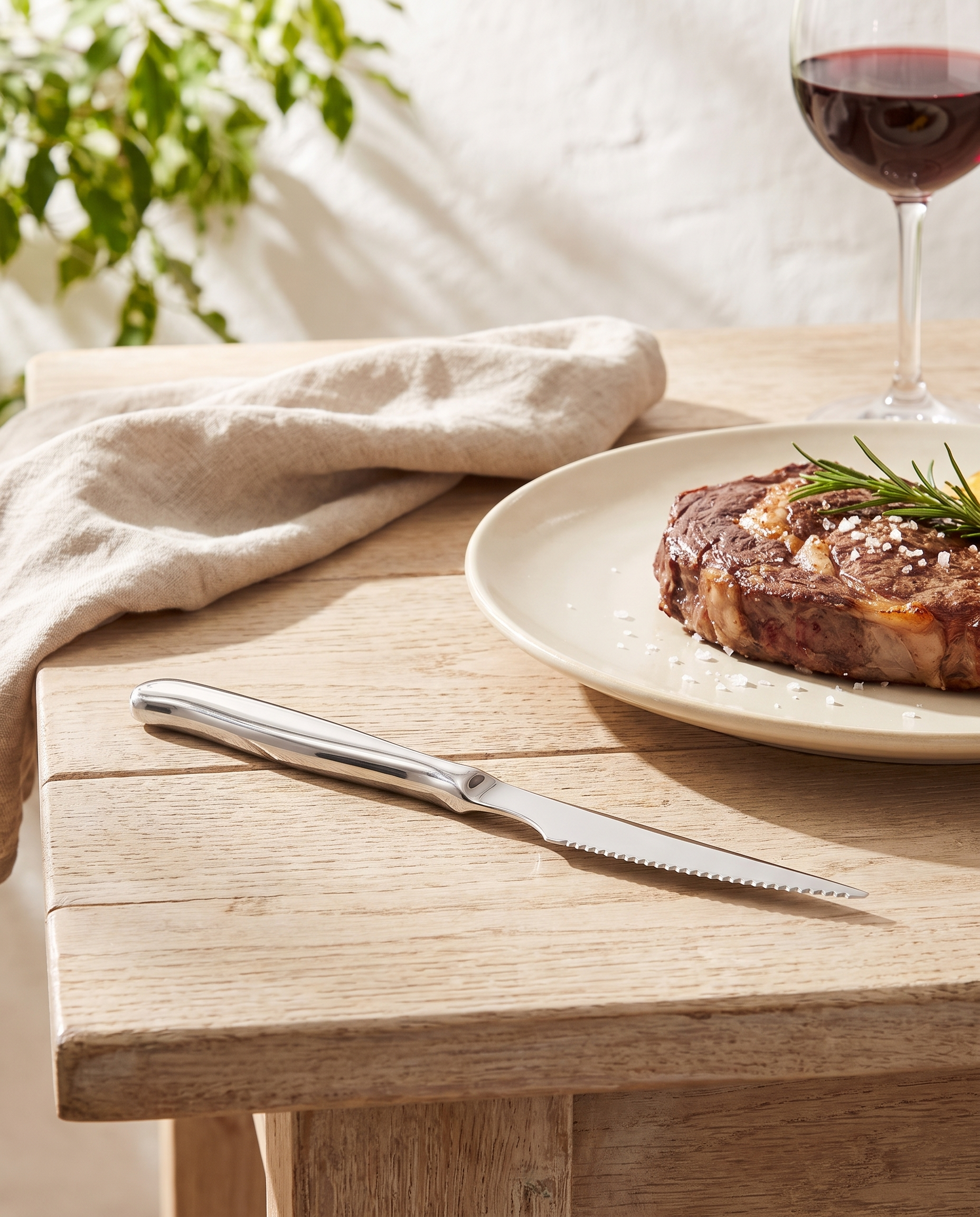Cuchillo chuletero Zurique sobre una mesa de verano con carne a la brasa