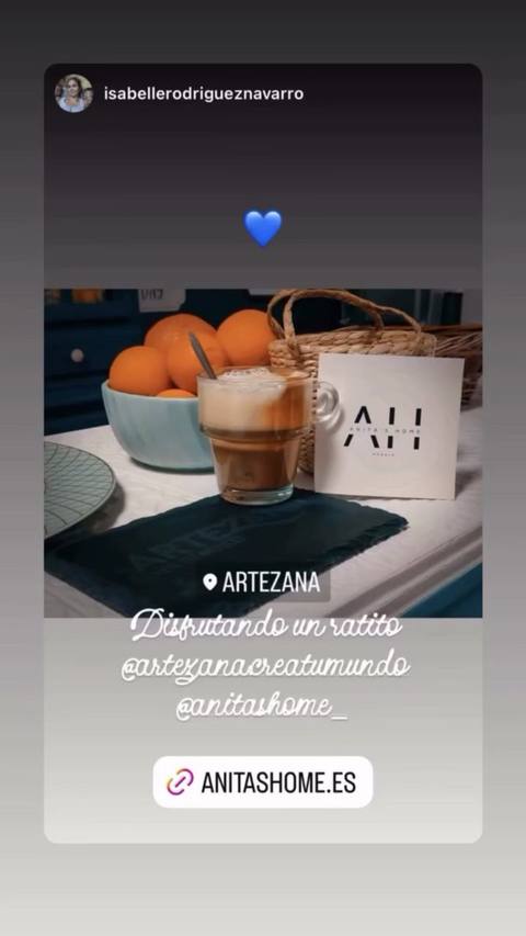 Café con leche en vaso alto junto a la bolsa de la tienda